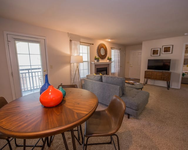 A living room with a grey couch, a wooden table, and a chair.