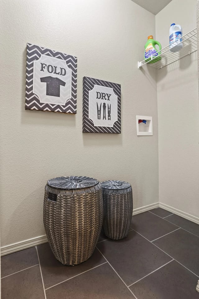 Two wicker baskets are on the floor under a sign that says "Fold T-shirt" and another sign that says "Dry VHB".
