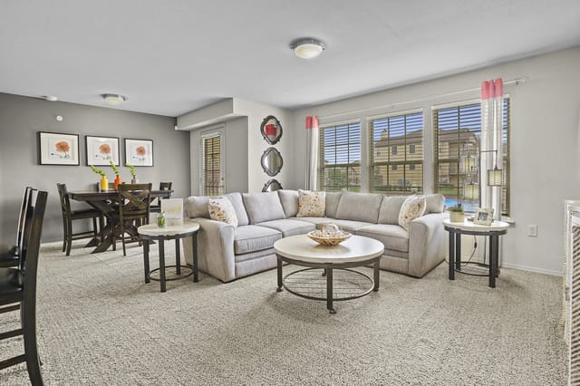 Living room with a sectional sofa, coffee table, and dining area.