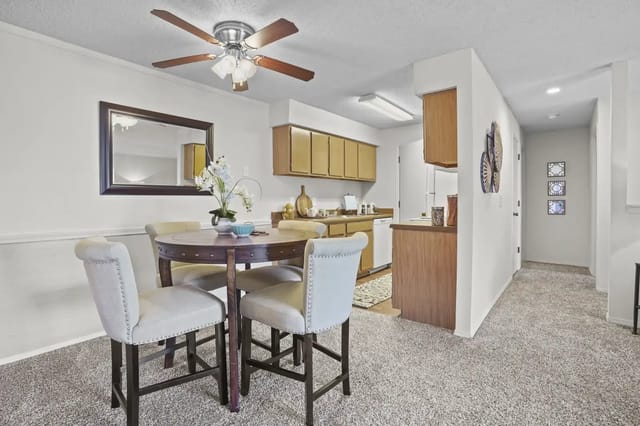 Cozy dining area with a round table and four chairs in an apartment kitchen.