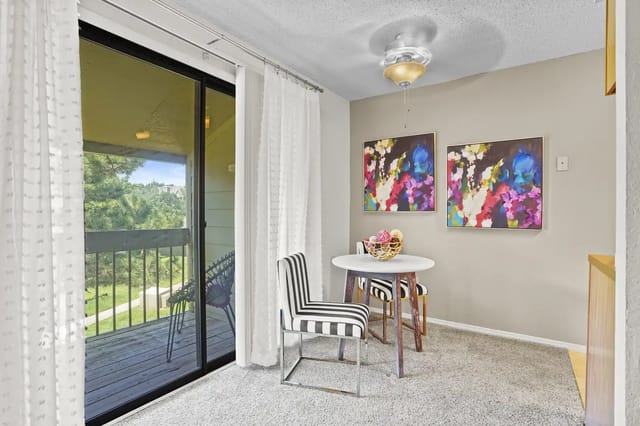 Cozy dining area with a round table and colorful artwork on the wall.