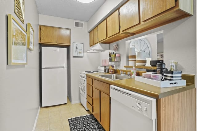 Bright kitchen area with wooden cabinets and appliances