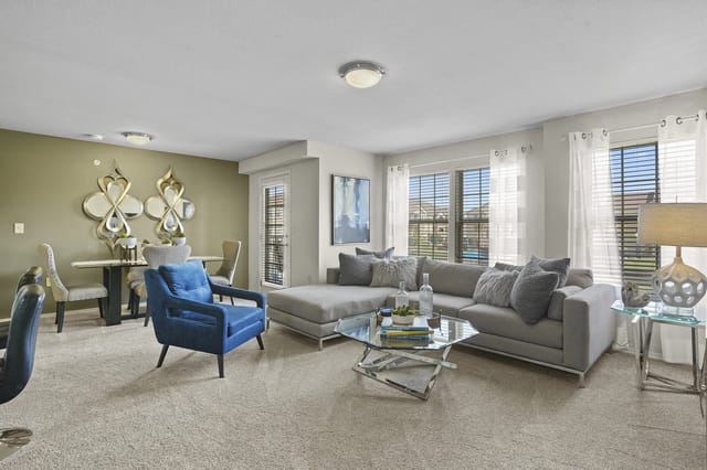 A living room with a blue chair and a grey couch.