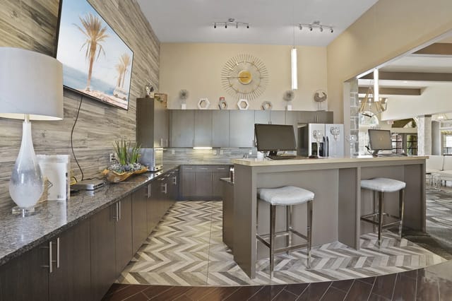 Modern leasing office with computers, kitchen counter, and seating area.