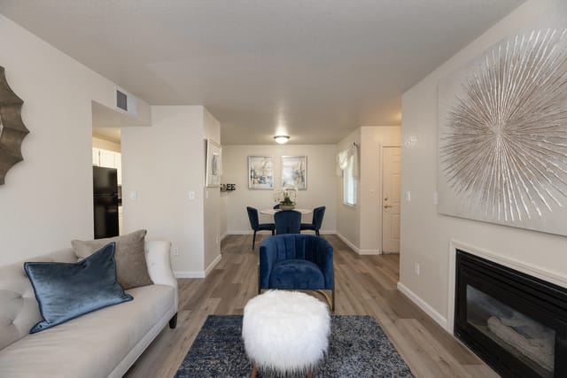 Living room with sofa, armchair, dining table, and fireplace.