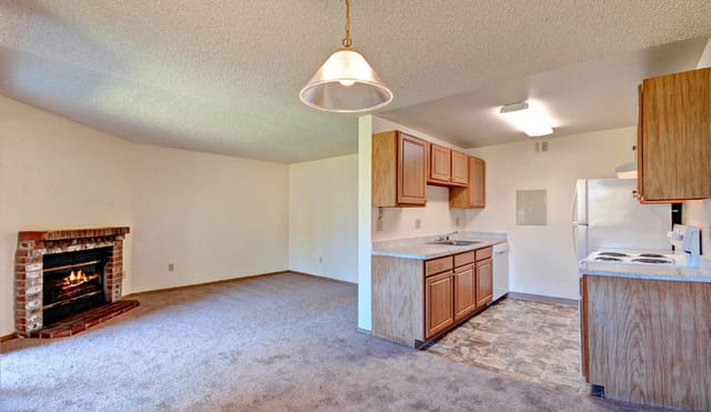 Living room with fireplace and adjacent kitchen