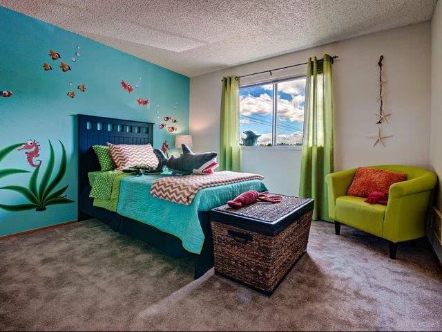Children's bedroom with an ocean theme, featuring a bed with shark and fish decorations.