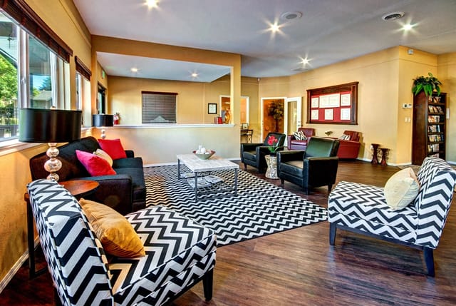 Interior lounge area with chevron patterned furniture and a large black and white rug.