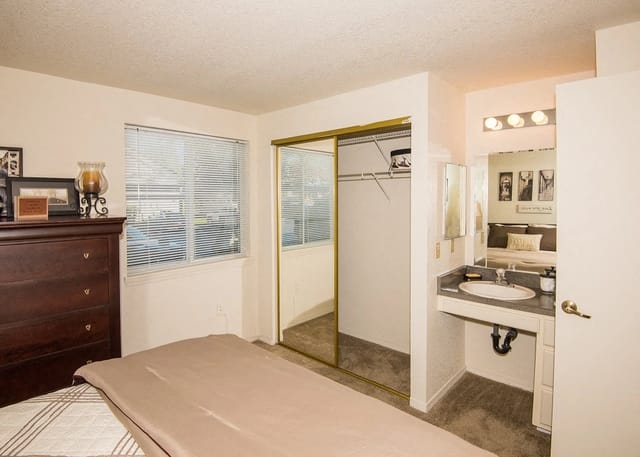 Bedroom with dresser, closet, and vanity.