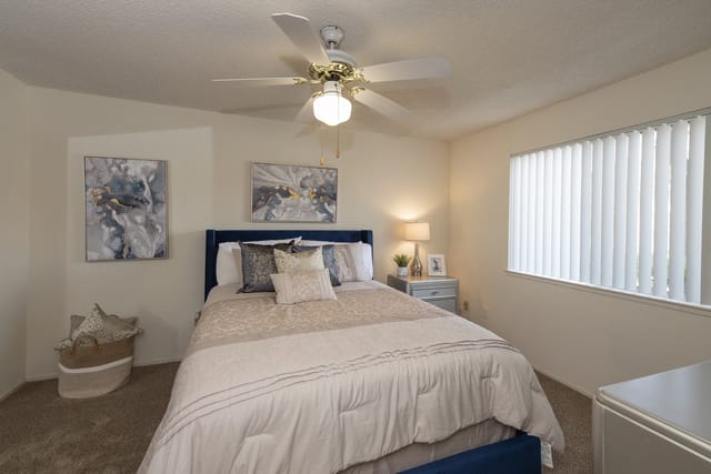Bedroom with a queen-size bed, nightstand, and window.