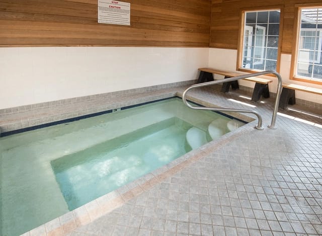 Indoor spa with wooden walls and tiled flooring.