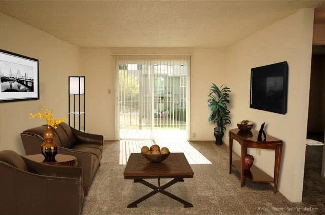 Living room with sofa, chairs, coffee table, and TV.