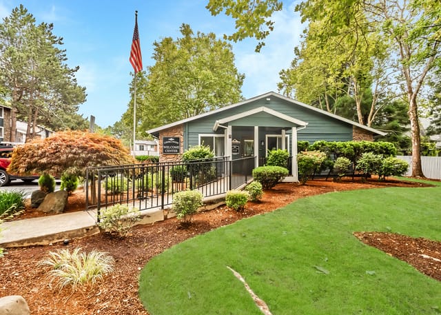 Exterior welcome center with ramp, railing, and landscaped grounds.