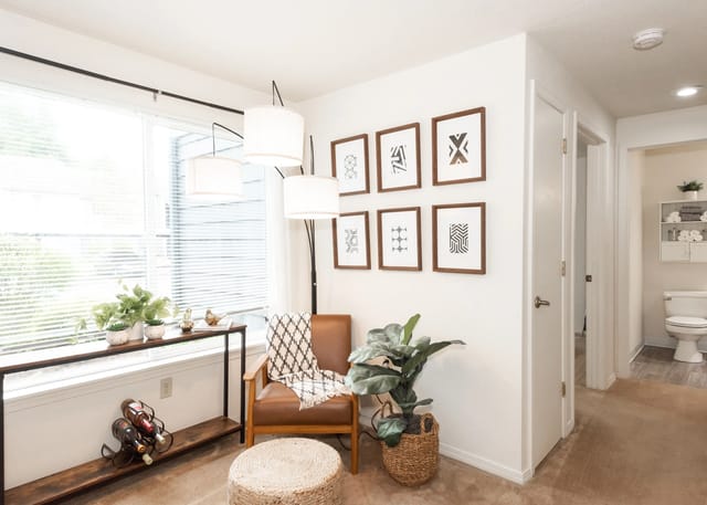 Living room with a leather armchair, decorative art, and plants.