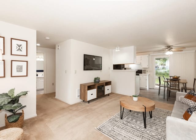 Living room with a TV, coffee table, sofa, and dining area.