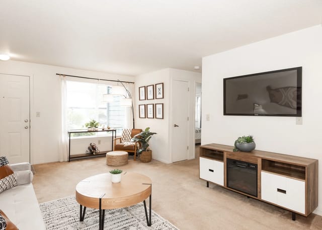 Living room with sofa, coffee table, armchair, TV, and entertainment center.
