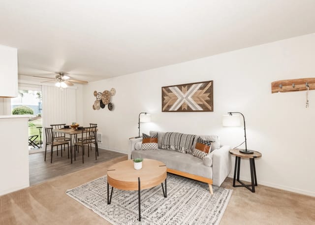 Living room with dining area featuring a gray sofa, coffee table, and dining set.