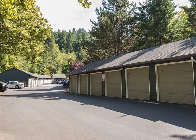 Row of garages with numbered doors and trees in background