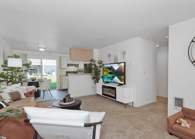 Living room and kitchen area with a TV, sofa, and dining table.