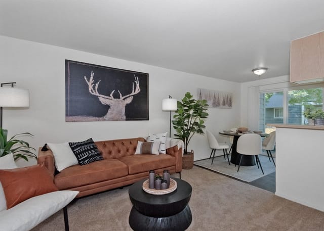 Living room and dining area with a brown tufted sofa, coffee table, and dining set.