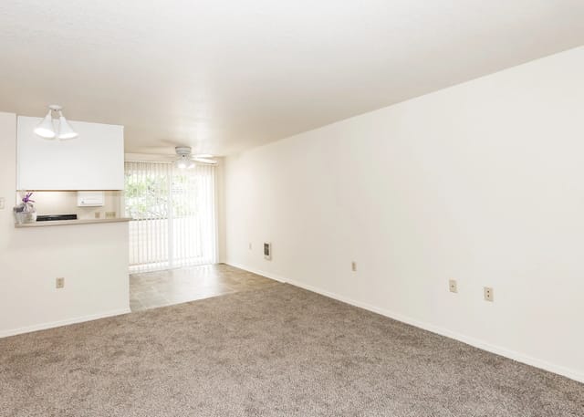 Spacious living room with carpeted floor and access to balcony.