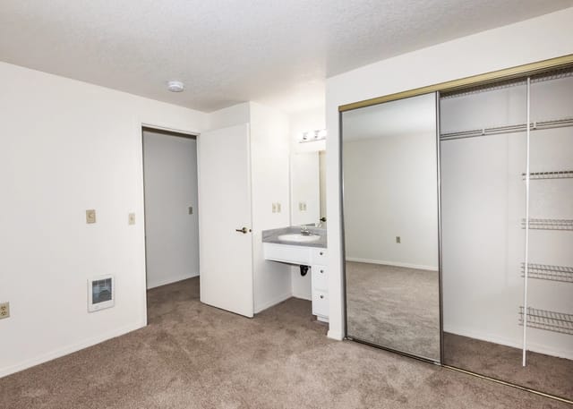 Bedroom with mirrored closet doors and vanity area.