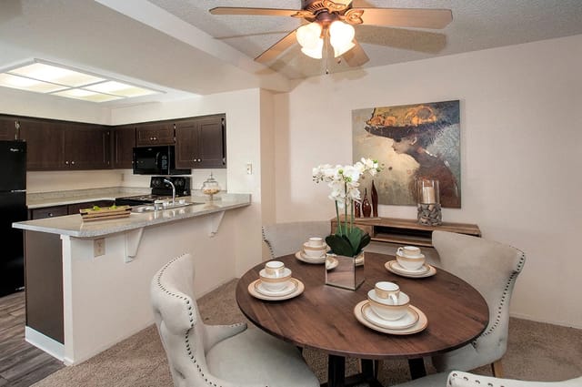 Dining area and kitchen with dark wood cabinets and granite countertops.