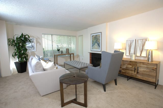 Living room with a white sofa, gray armchair, fireplace, and decor.