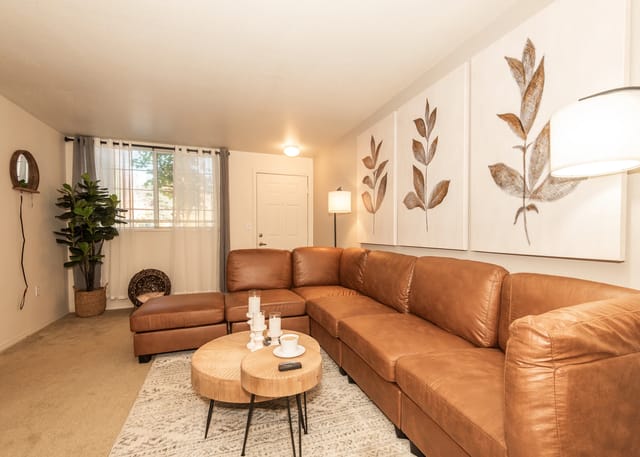 Spacious living room with a large leather sectional sofa and coffee table.