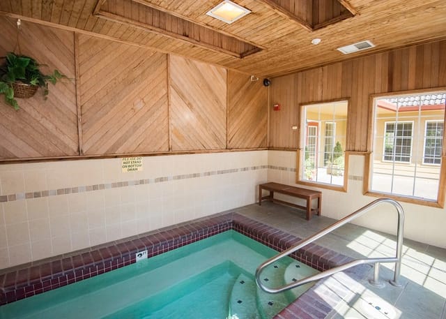 Indoor spa with wooden paneled walls and tiled surrounds.