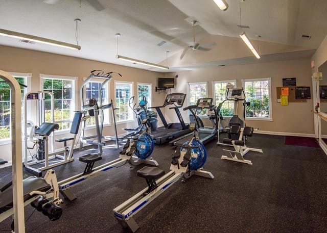 Fitness center with treadmills, rowing machines, and weight machines.