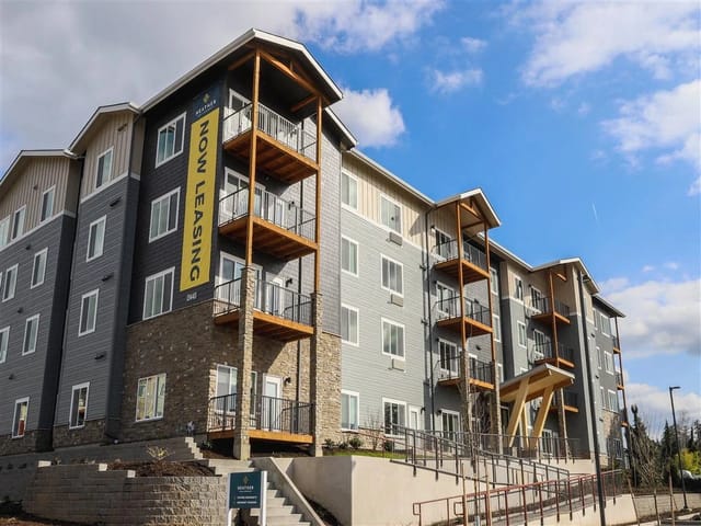 Exterior of the Heather apartment building with a 'Now Leasing' banner.