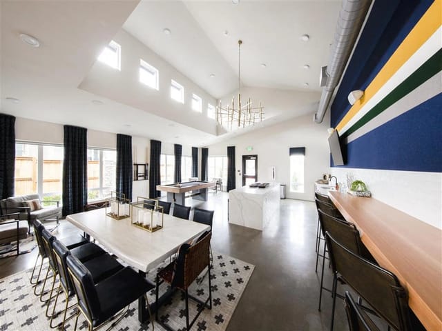 Community lounge area with dining table, pool table, and bar.