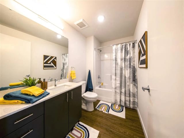 Modern bathroom with vanity, toilet, and shower.