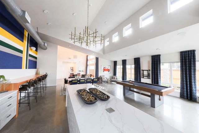 Community lounge area with a billiards table and bar seating.