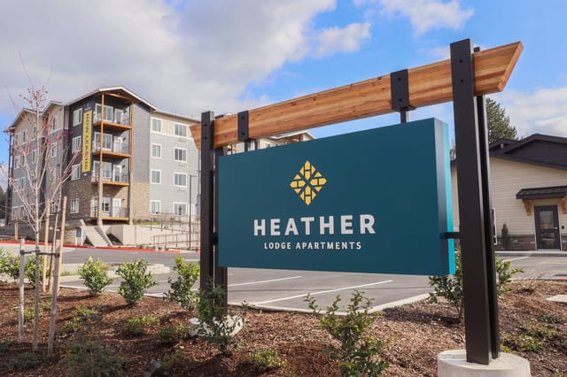 Heather Lodge Apartments monument sign with building in background