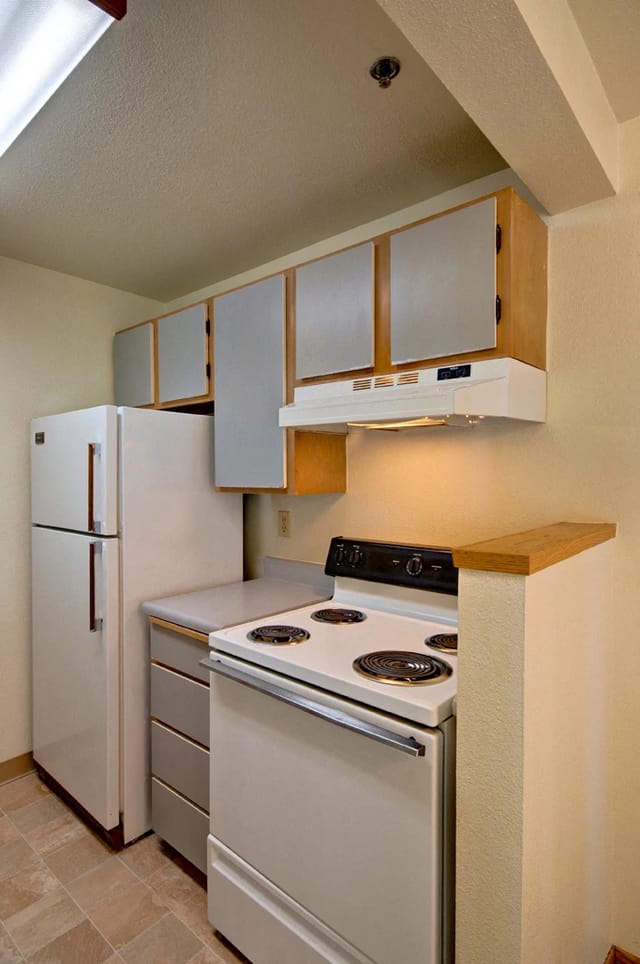 Kitchen with white refrigerator, stove, and cabinets.