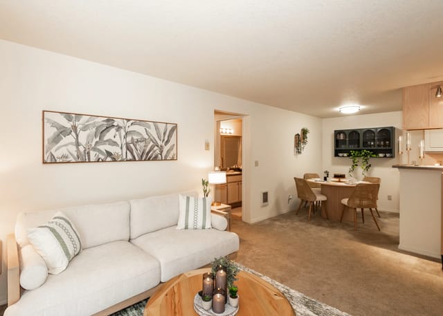 Living room and dining area with a sofa, coffee table, and dining set.