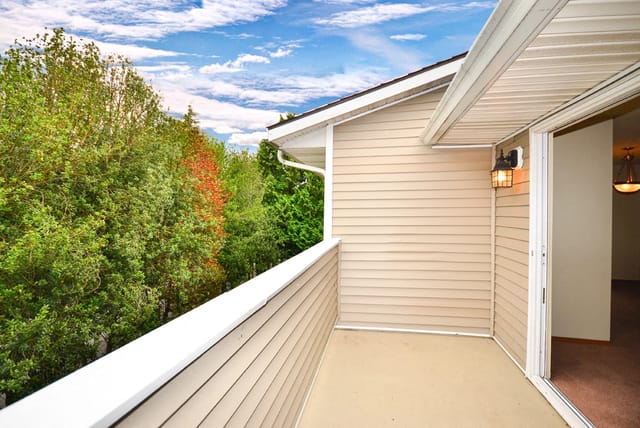 Balcony overlooking trees and blue sky.
