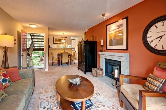 Living room with a fireplace, dining area, and entryway.