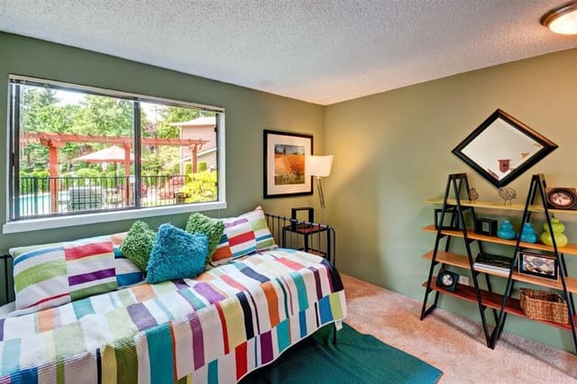 Bedroom with a twin bed and a window overlooking the pool area.