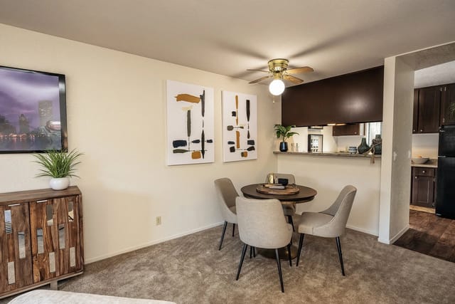 Dining area with a round table and chairs next to a kitchen counter.