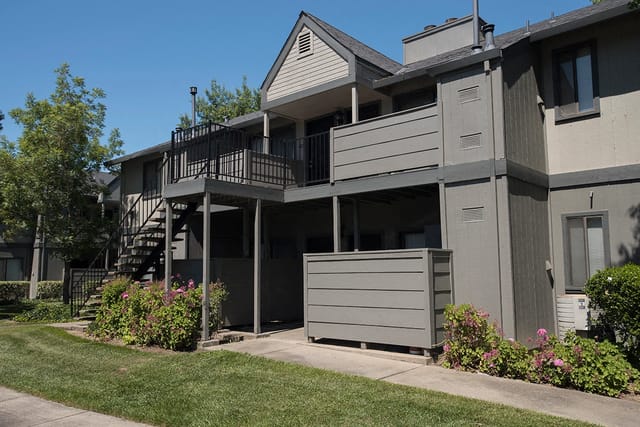 Exterior view of apartment buildings with stairs and balconies.