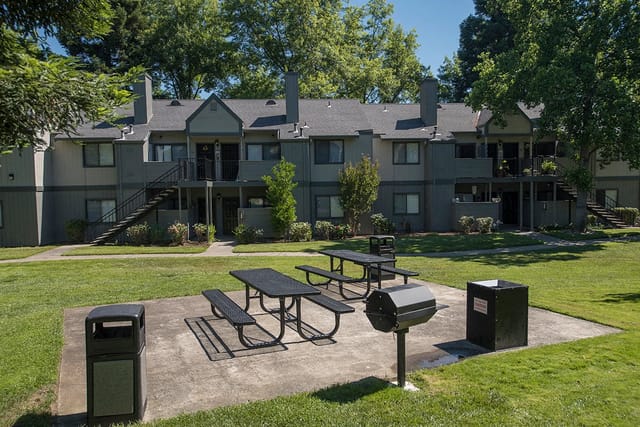 Outdoor picnic area with grills and seating.