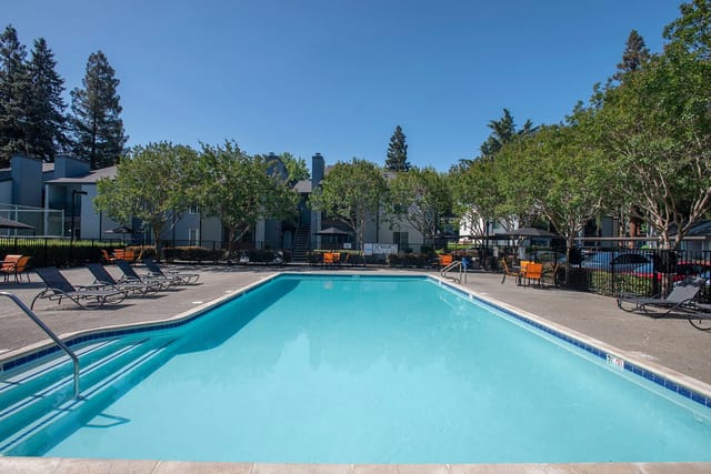 Outdoor swimming pool with lounge chairs and seating areas.