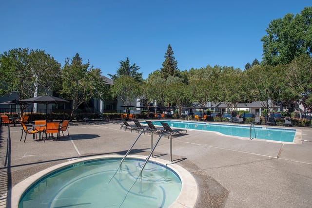 Pool and hot tub area with lounge chairs and outdoor seating.