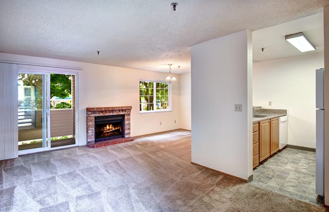 Living room with a fireplace and a view of the kitchen.