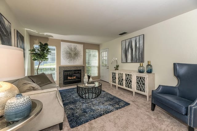 Living room with fireplace, sofa, coffee table, and accent chair.
