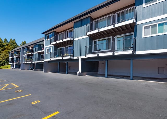 Exterior view of apartment building with balconies and parking lot