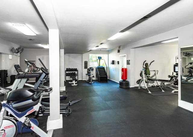 Fitness center with cardio machines, weight benches, and free weights.
